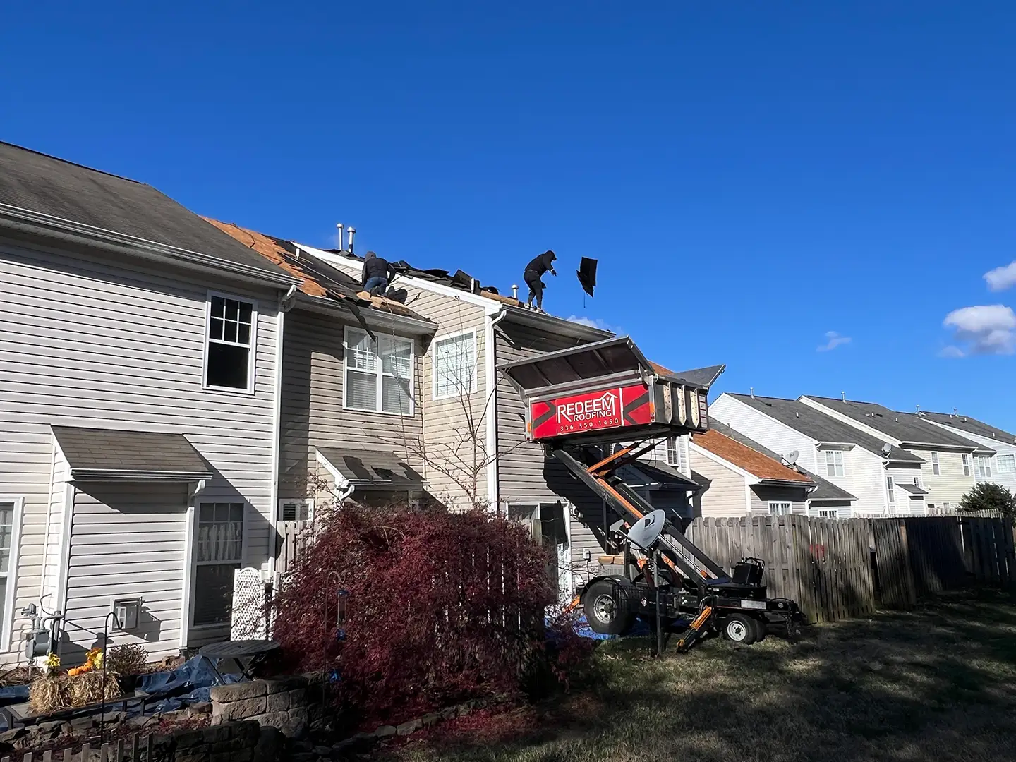 Storm-damaged roof being torn off by Redeem Roofing